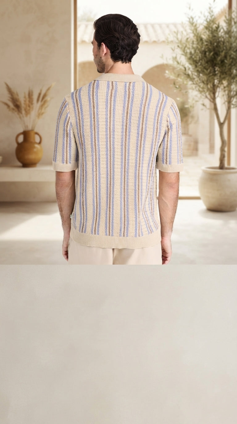 A man wearing a vintage knit polo in a minimalist, light-filled setting with ample negative space for text.